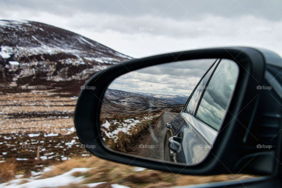 Road reflection in car mirror on motion