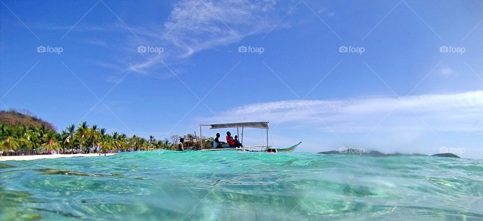 People in the boat sailing thru the coast during the hot summer days