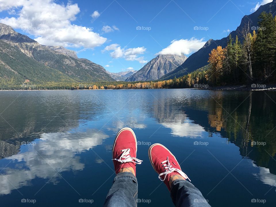 My feet over water the lake in Glacier National Park.