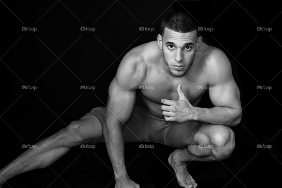Muscular man exercising over black background