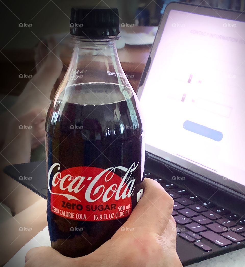 Refreshing Coca Cola while working at home.