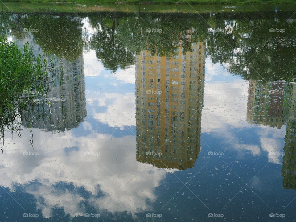 mirror image of houses in the lake of the park of the city of Kiev