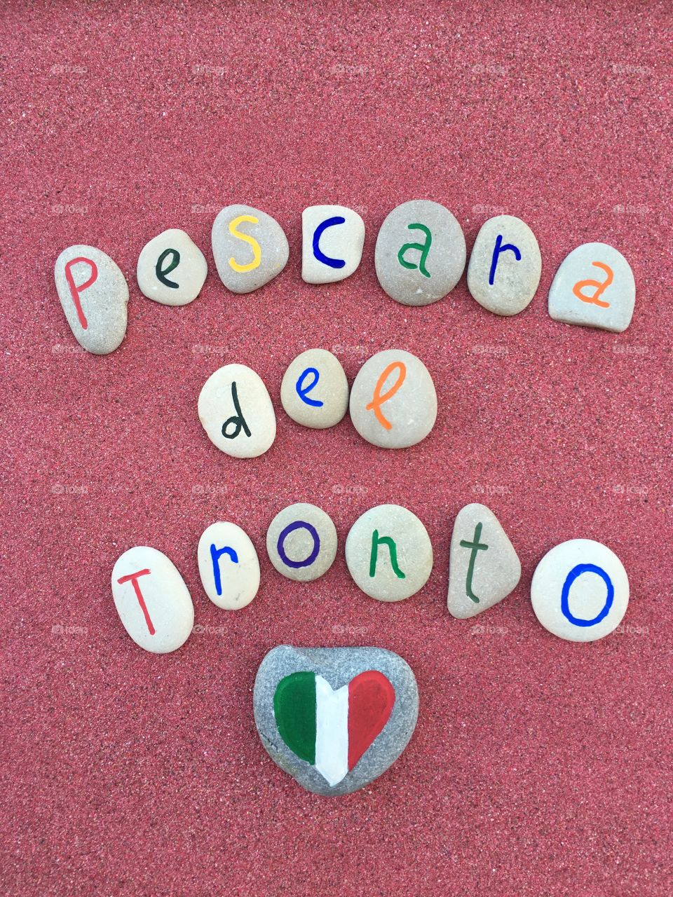 Pescara del Tronto, memorial stones composition on red sand 