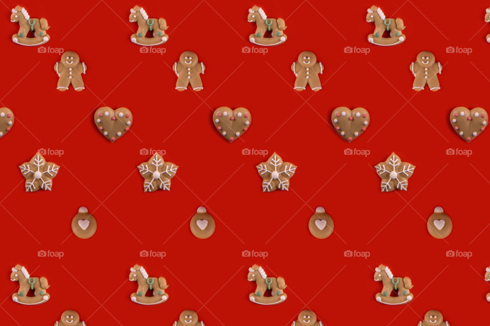 Pattern of gingerbread cookies on red background