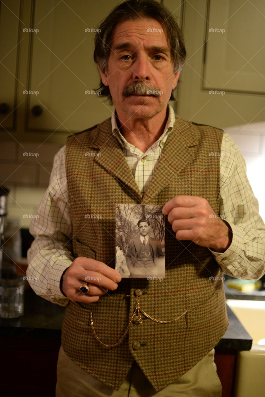 Portrait of a man holding old photograph