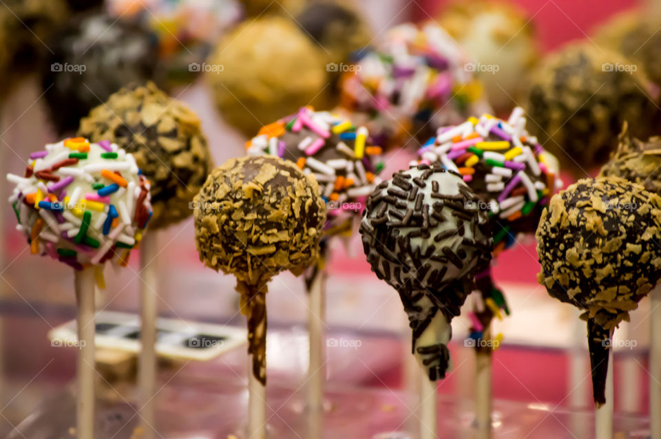 Chocolate cake pops with colorful rainbow sprinkles conceptual fun treat, party or bake sale goodies background photography 