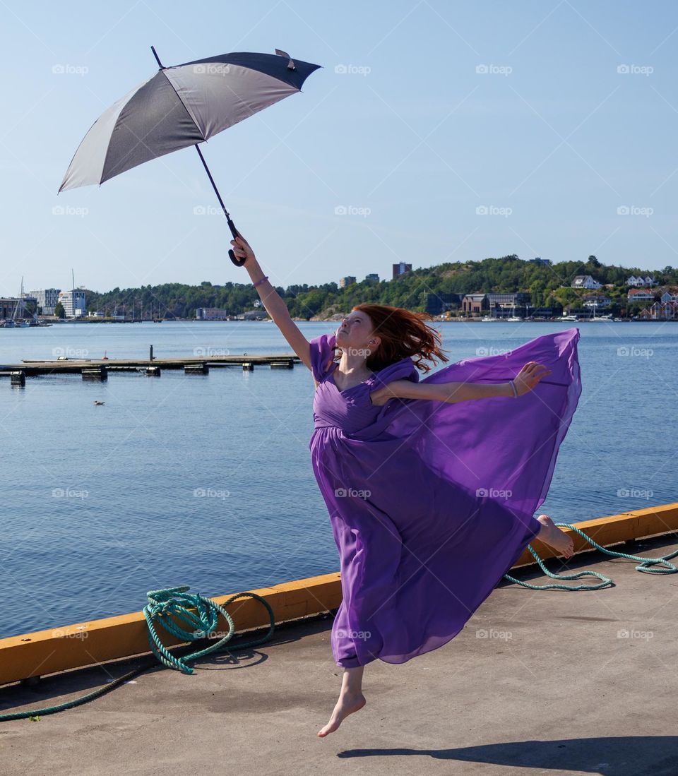 young ballerina girl ,dancing at the Bay into the wind weather.