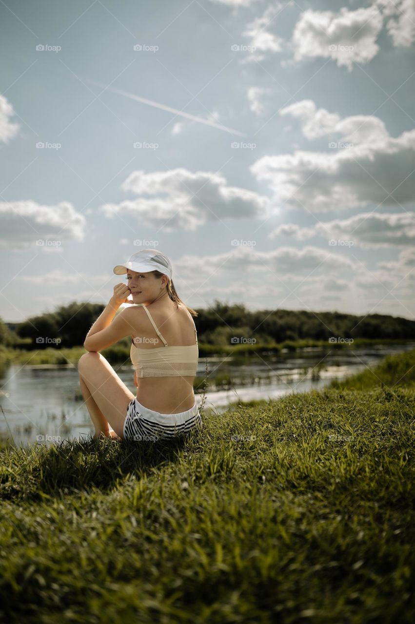 girl resting meditation on the river bank