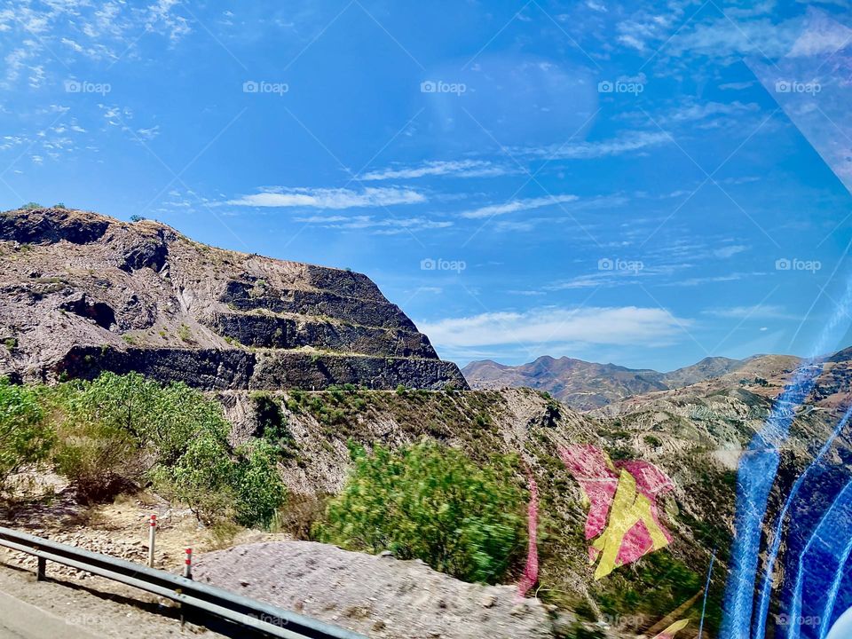 These are the „Andes“ mountains that surround the „Uyuni Salt Flat“. The photo was taken en route to the small town of „Uyuni“ at the edge of the salt flat. One to three day tours are offered to explore its riches. 2022. Hypnotic Productions