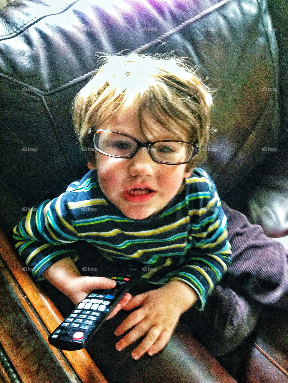 Content and happy toddler boy at home wearing moms glasses