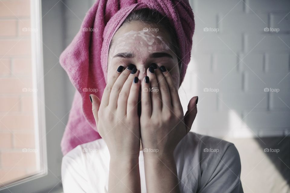 Woman applying cream on her face