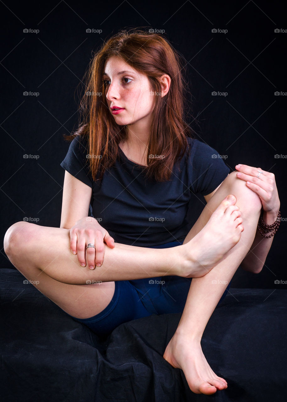 Woman exercising on black background
