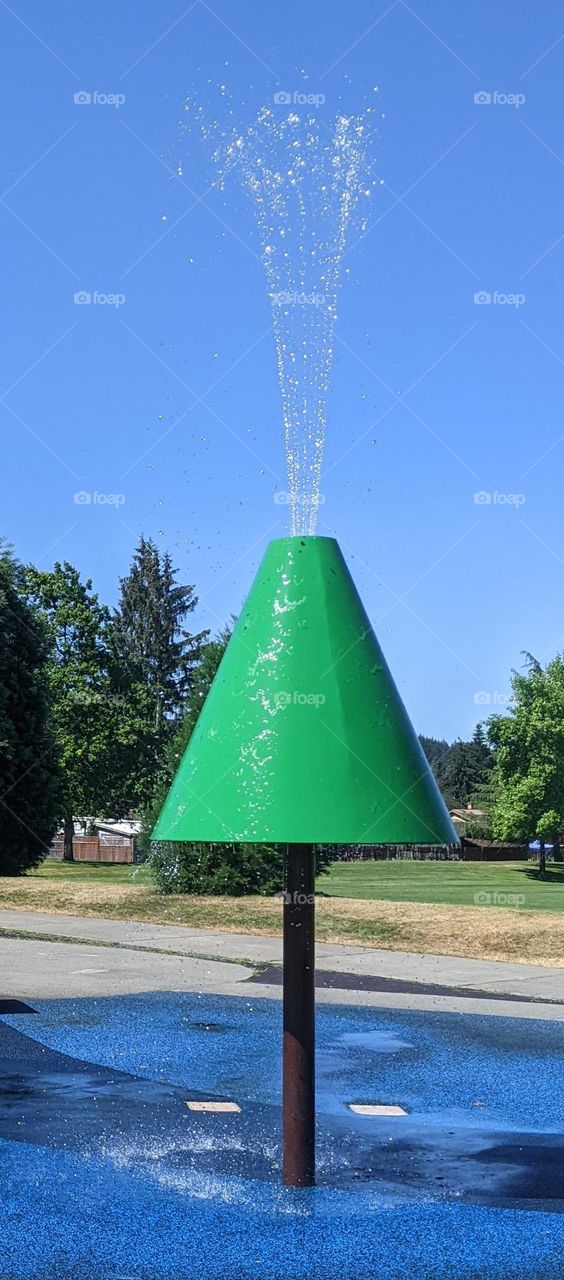 metal structure in a Spraypark resembling a pinetree spraying water
