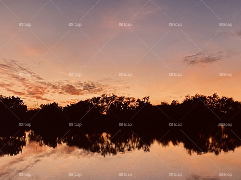 Twilight has appeared trying to cast beautiful colours, but the sky is saying something different. The mirrored Reflections off the lake water is also telling the story. 