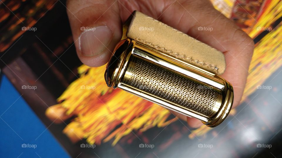 mão segurando um barbeador elétrico. Background.