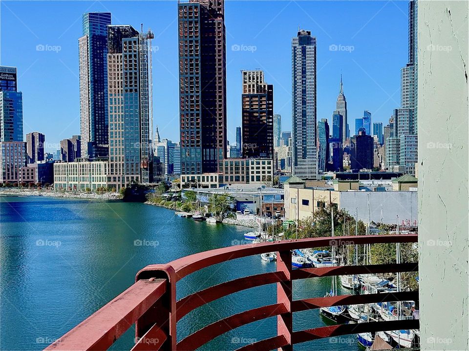 This is the gorgeous view from the pedestrian outpost on top of the „Pulaski Bridge“ at „Newtown Creek“ in LIC, Queens with its boats of different kinds and sizes on a warm sunny Indian summer afternoon in early November 2023. Hypnotic Productions