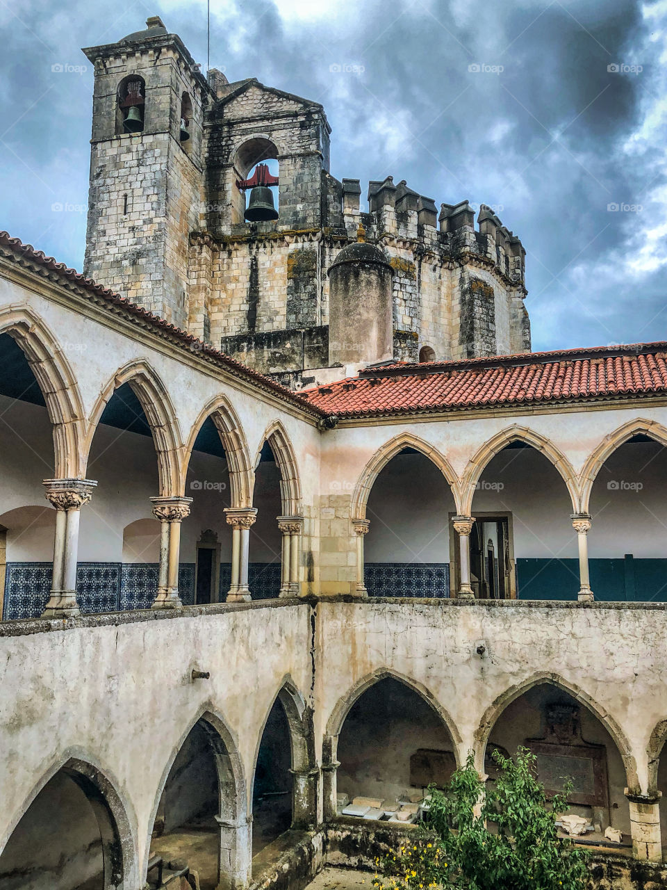 Arched cloisters in front of the bell tower and round church at The Convent of Christ, Tomar, Portugal 