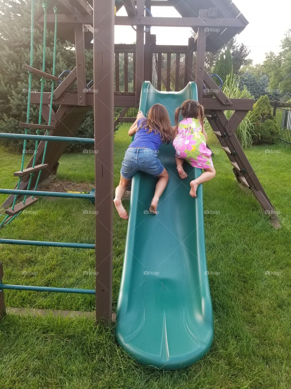 Sister race up the edge of the slide!