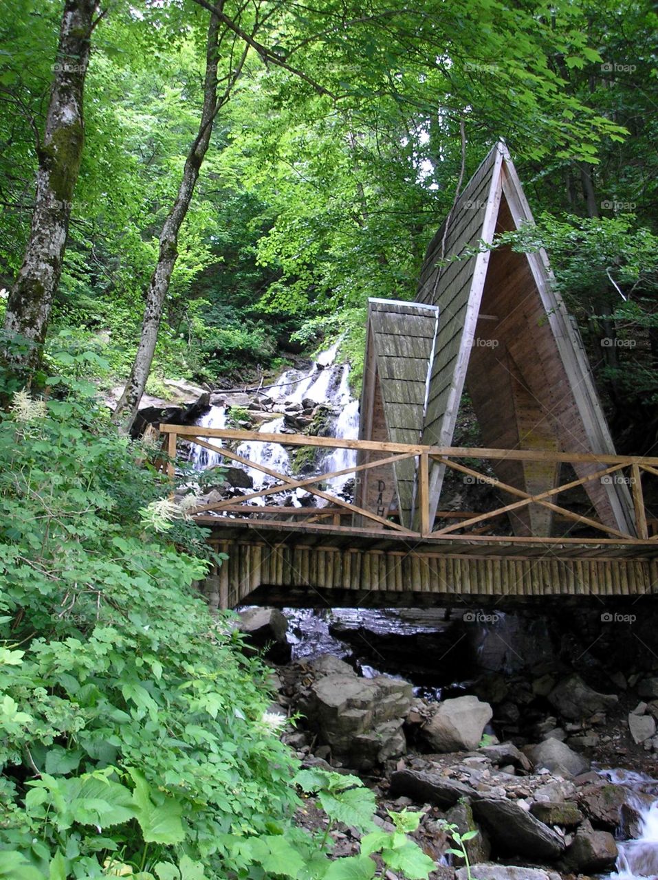 A wooden cabin a mountain waterfall Trufanets in Carpathian Mountains 