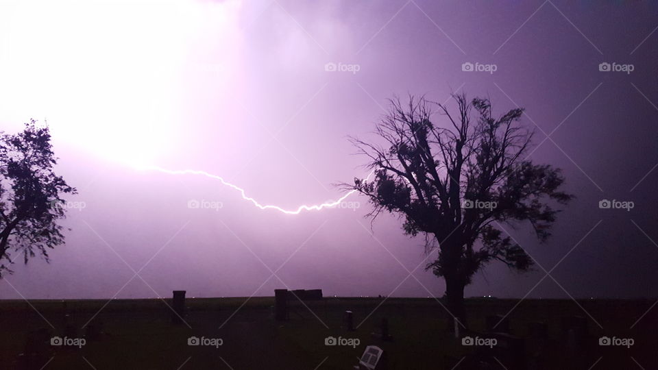 Streak of Lightning in Sky at Night at Cemetery