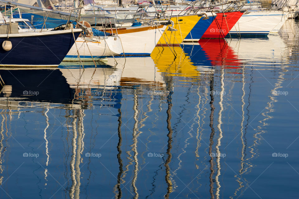Reflection of multicolored boats in water