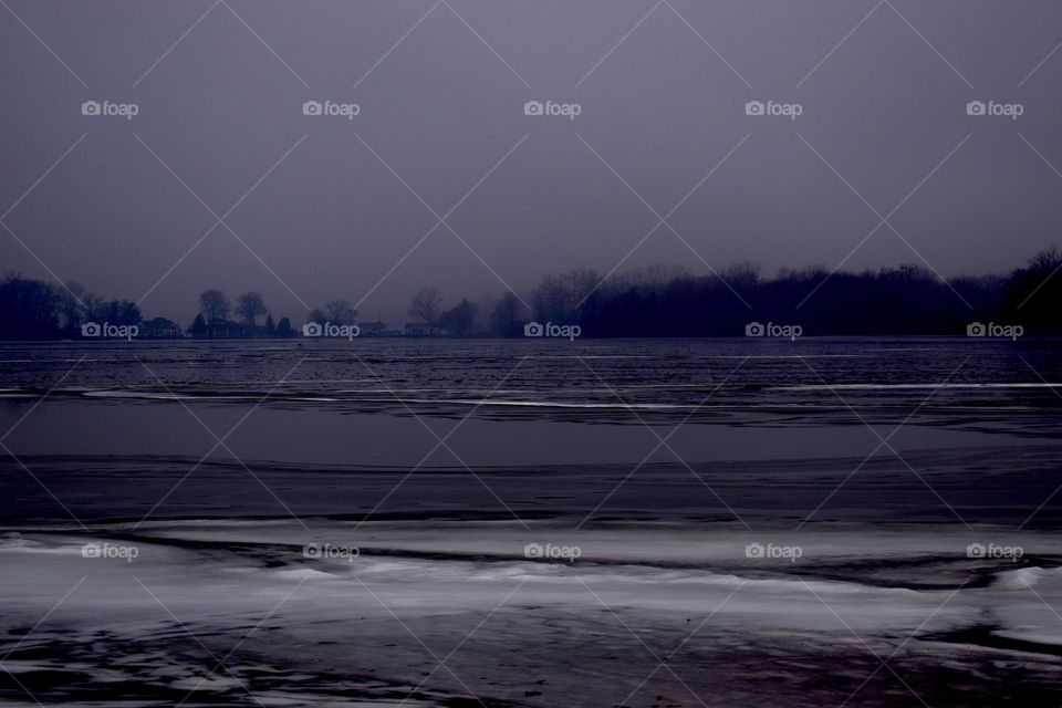 Nightfall on the edge of an icy lake
