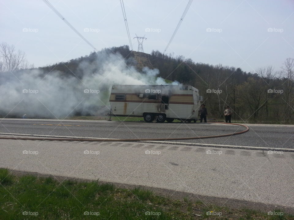 Camper fire. Camper on fire along side road