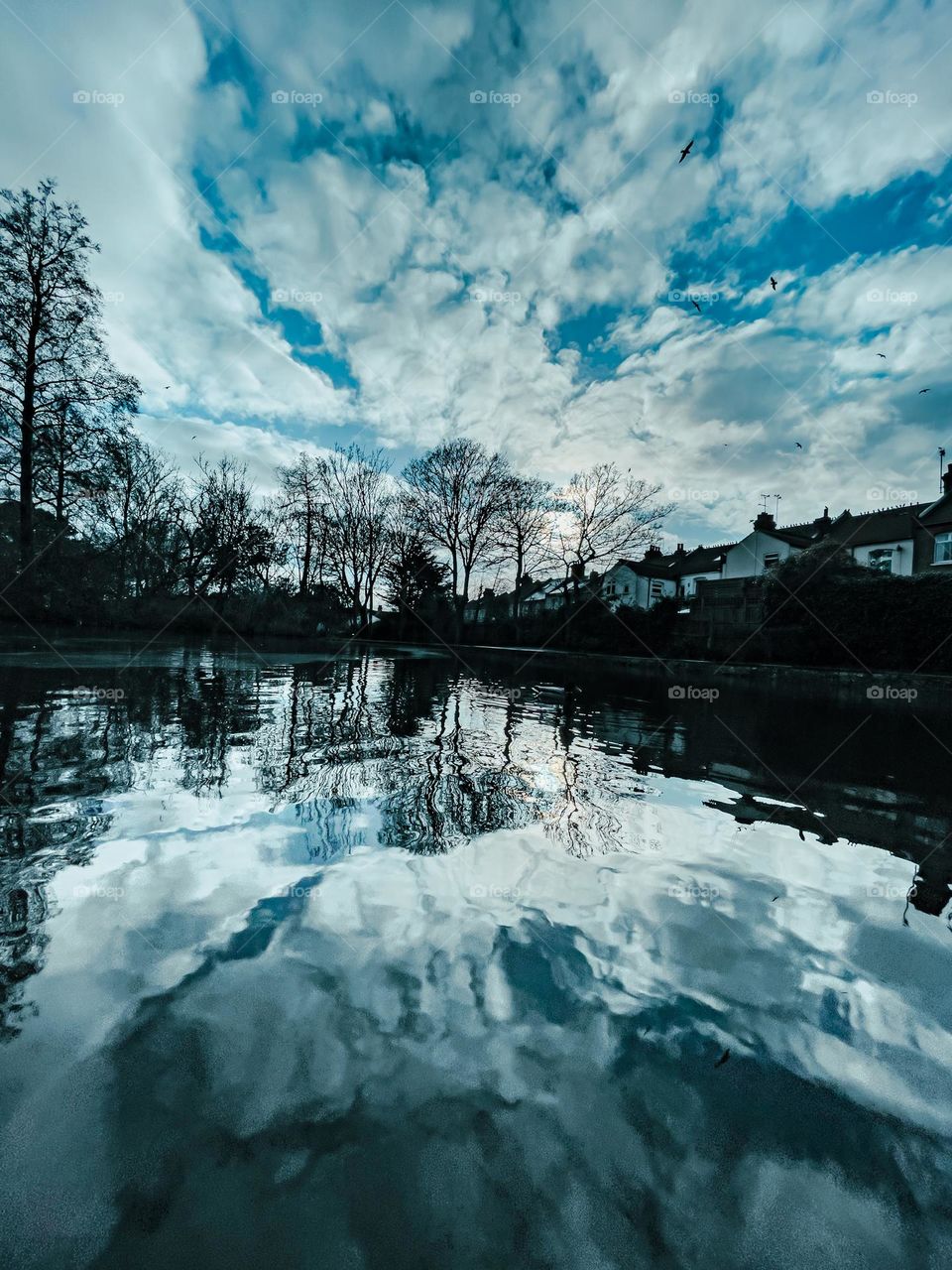 Mystic reflections on the water on a cloudy blue skied day