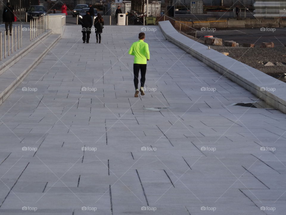 Urban running. A man running over the operaroof in Oslo, Norway