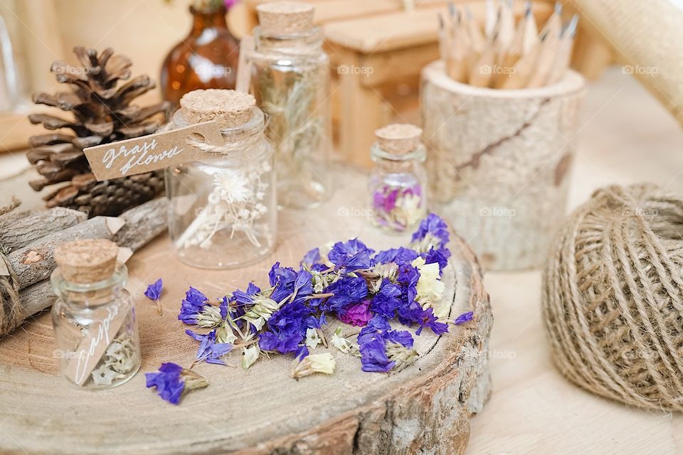 dried flowers on the wooden stump display with selective focus on the dried statice flowers (purple flowers). vintage and nostalgic still life.