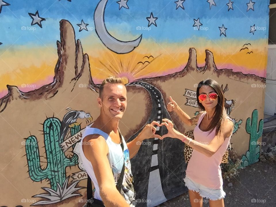 Loving couple. Loving couple in front of the route 66 painting on a wall at Oatman ghost town,AZ