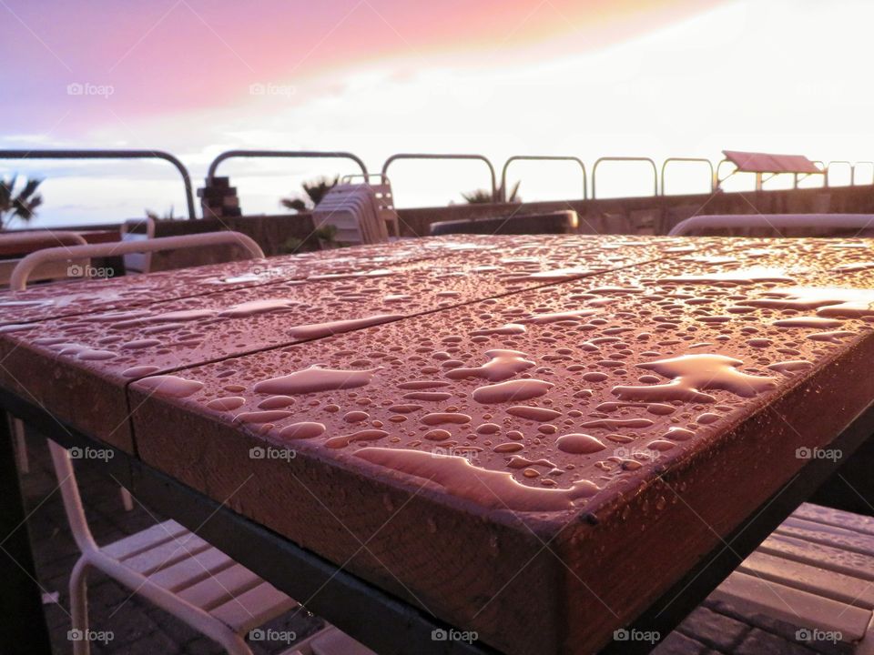 outside wooden table after rain at sunset