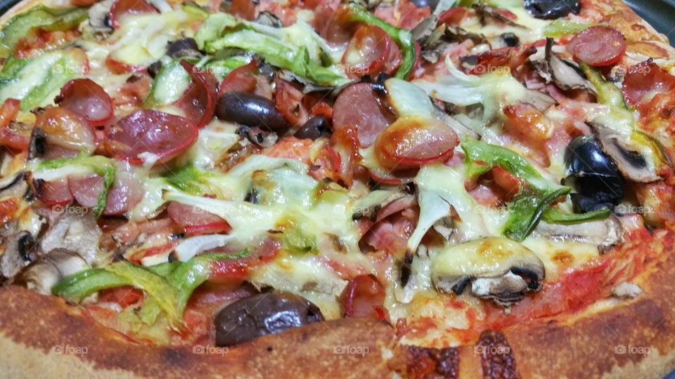 Close up of pizza with an assortment of ingredients.