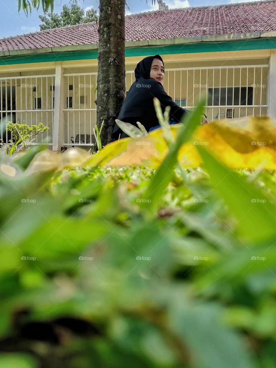 A teenage girl is relaxing on the grass.