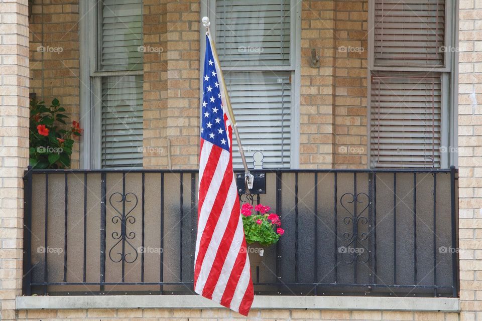 American Flag displayed on a porch of a city home