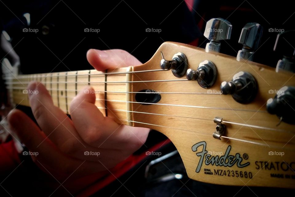 Man Playing a Fender Guitar