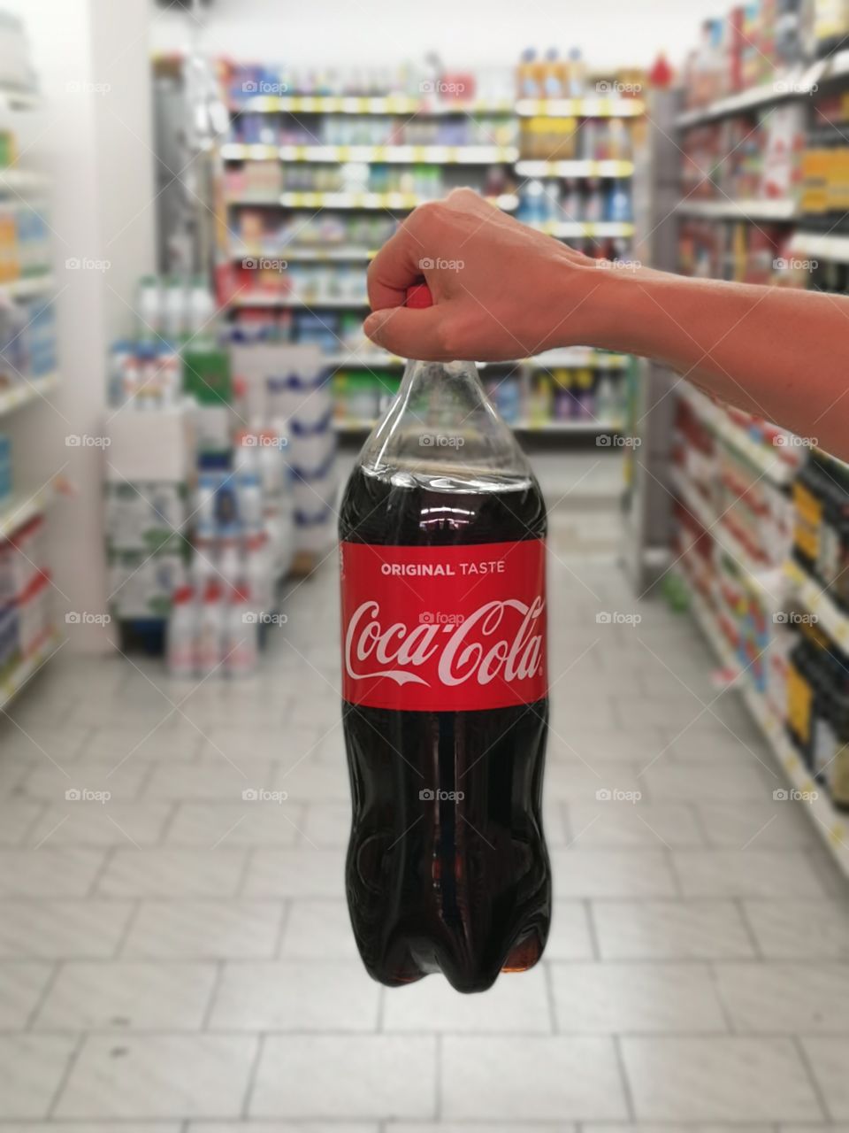 woman holds bottle of coca cola in the supermarket