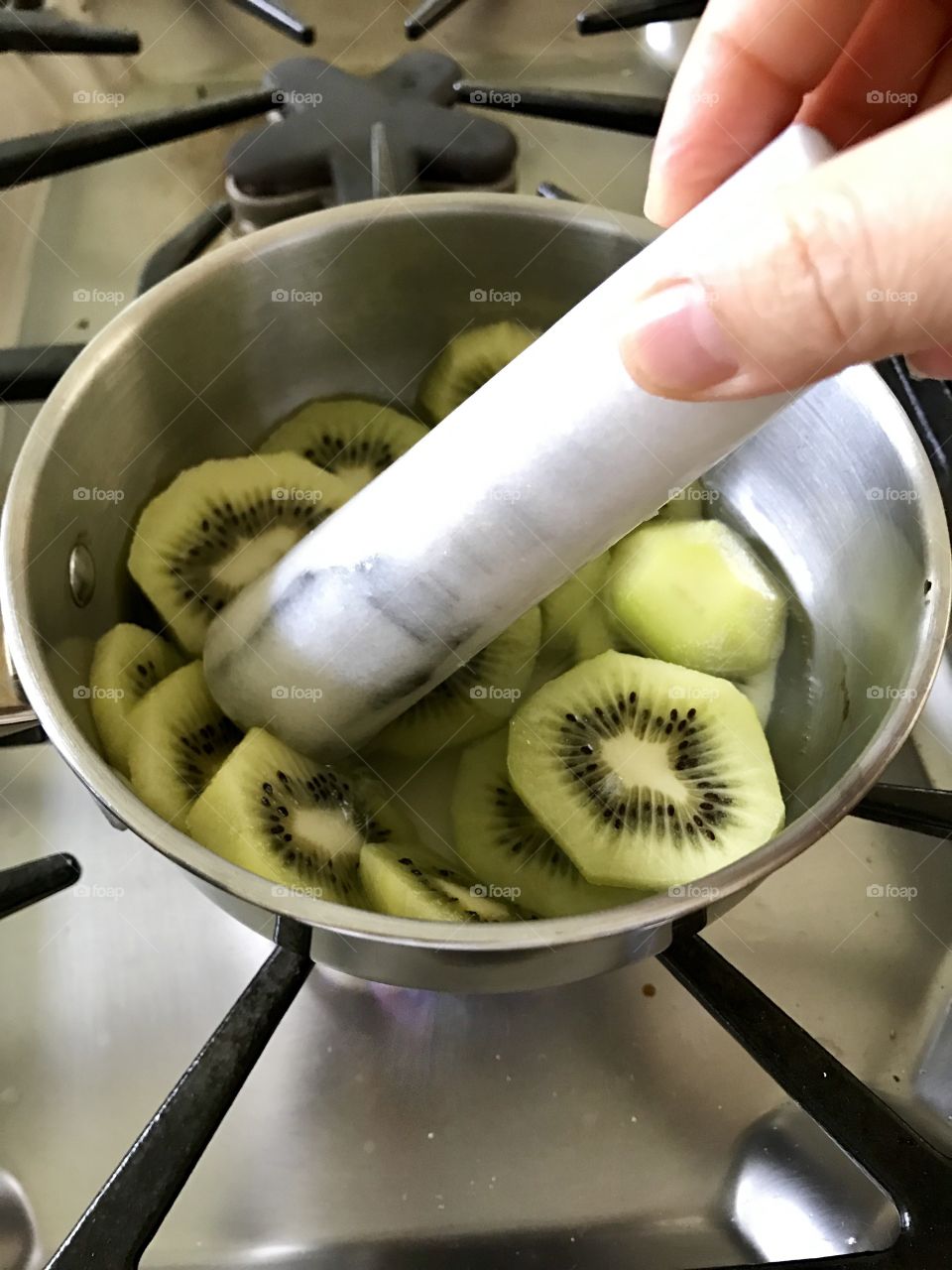 Smashing kiwi to make kiwi jam