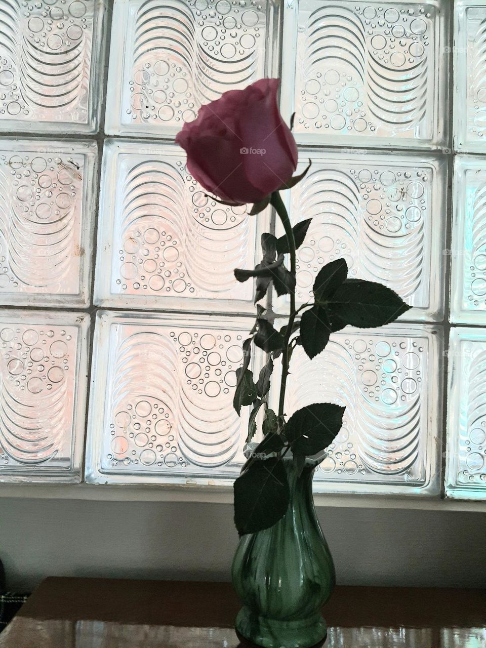 A pink rose in a vase with nice smell