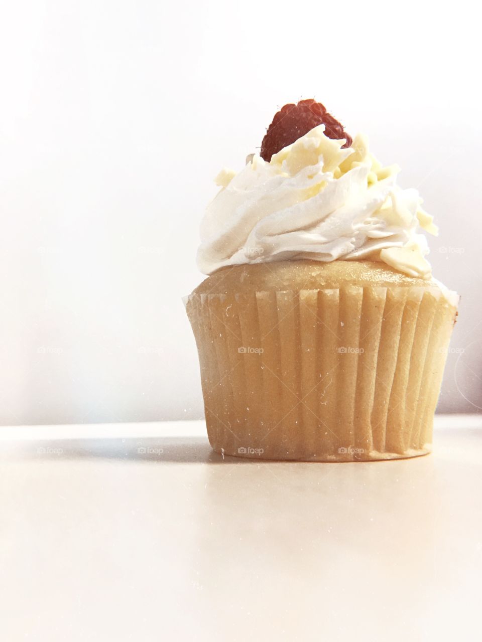 A raspberry white chocolate cupcake with plain background