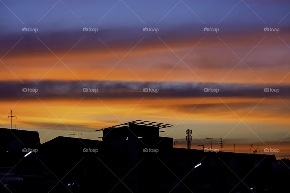 Beautiful light of Sunset with clouds in the sky reflection behind the building.