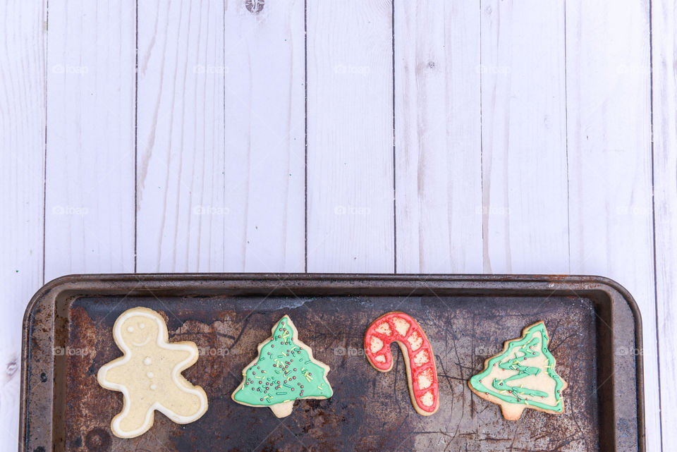 Flat lay of a row of Christmas cookies on a rustic baking sheet