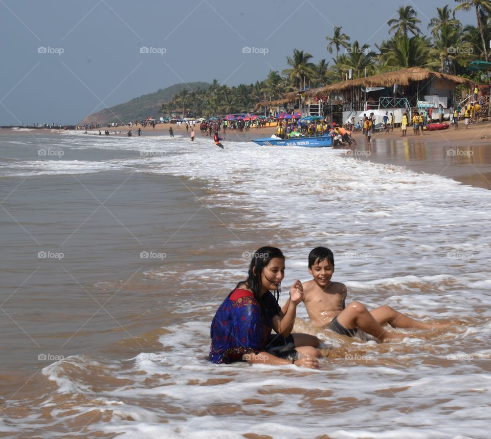 kids having fun inside water on beach in summer