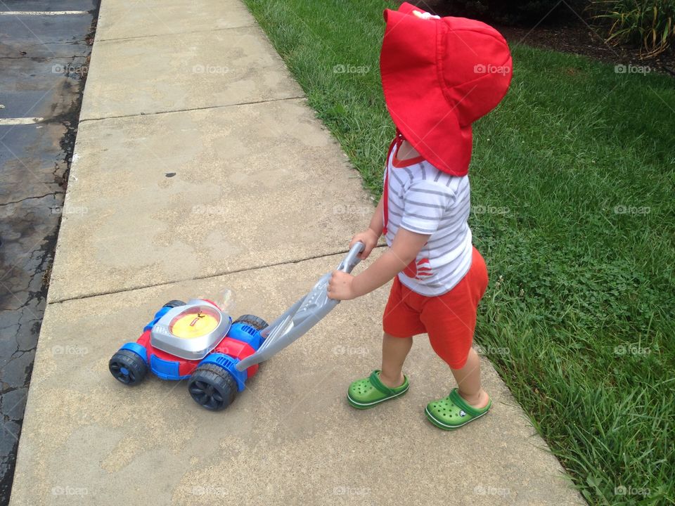 Toddler mowing the lawn.