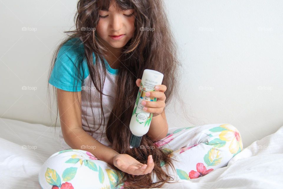 Girl with gorgeous long healthy hair os using Herbal Essences hair solution