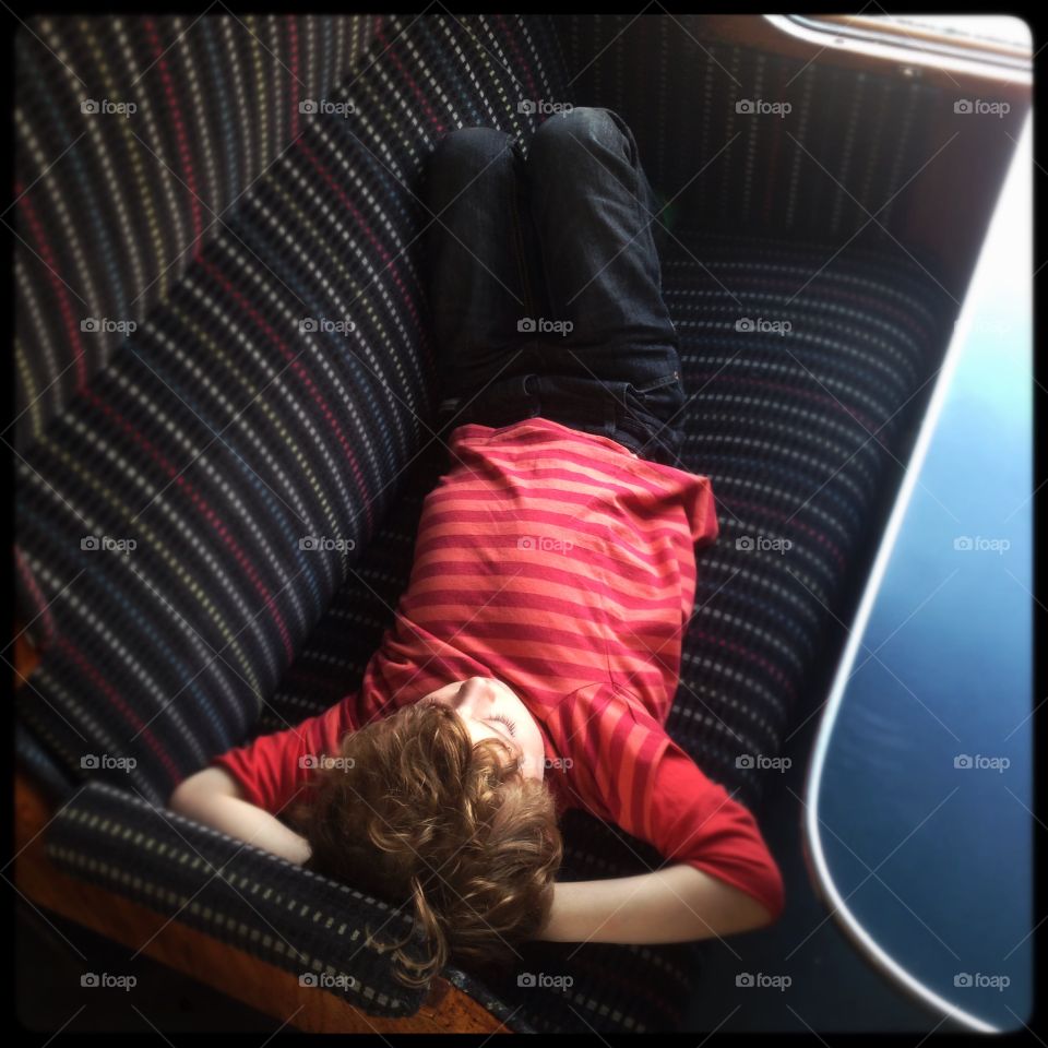 Five year old boy resting. Five year old boy resting on a train bench.