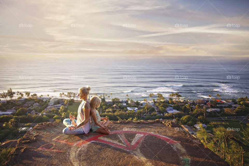 Mother and daughter yoga poses on the north shore of Oahu after a long hike! Tons of waves and a colorful sunset 