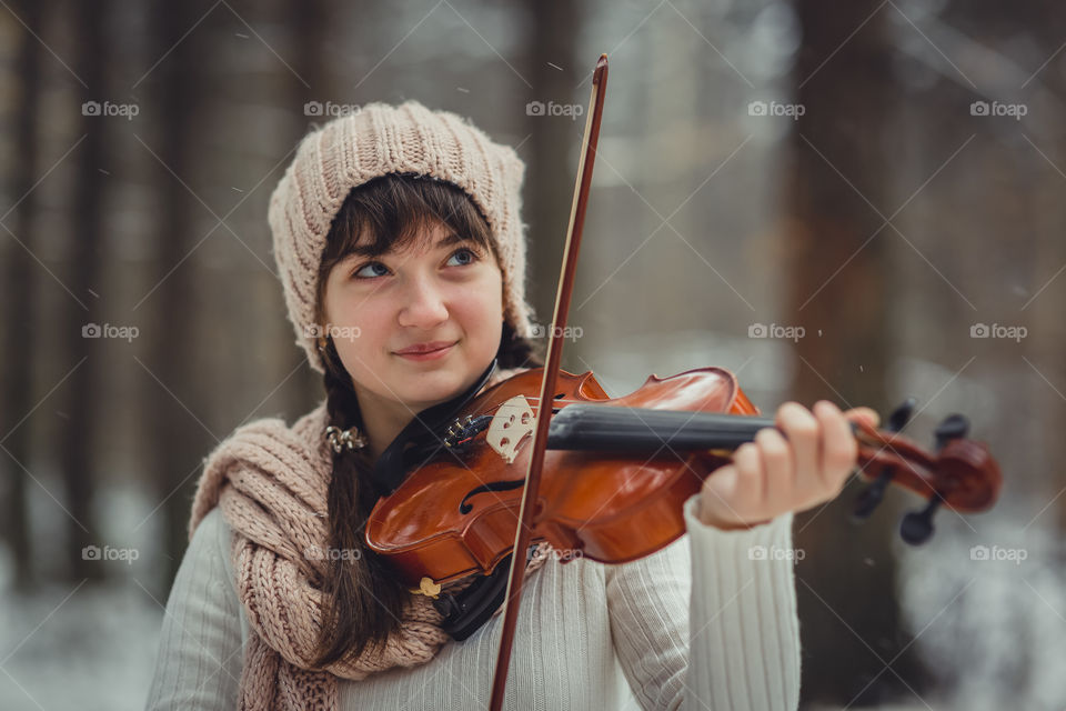 Teenage girl portrait with violin in winter park