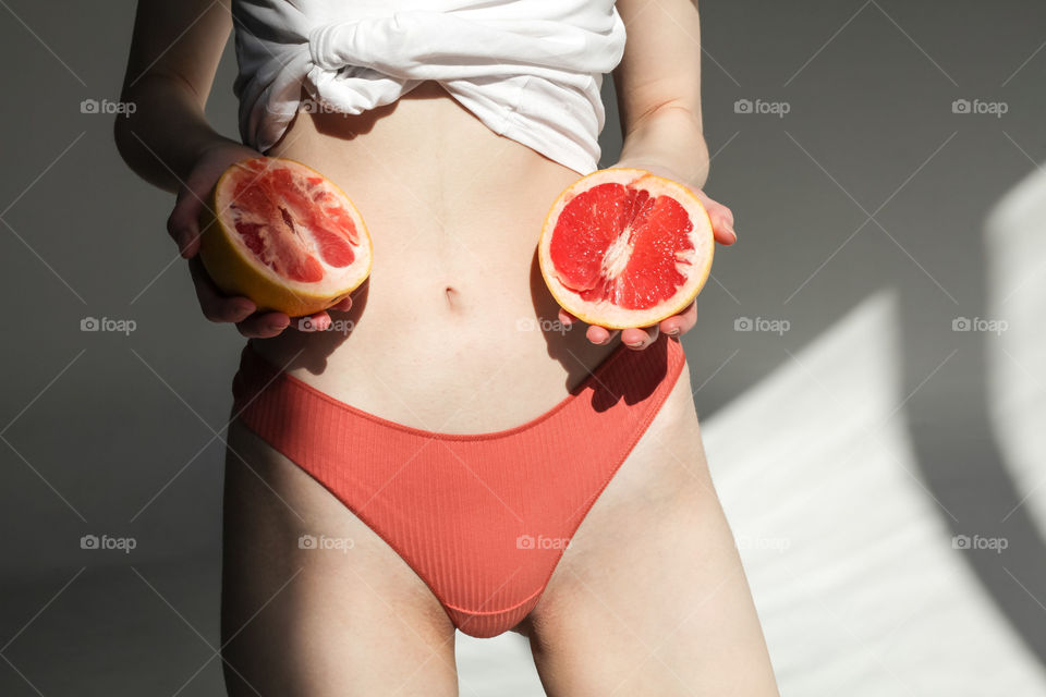 summer concept photo, woman in lingerie holding grapefruit