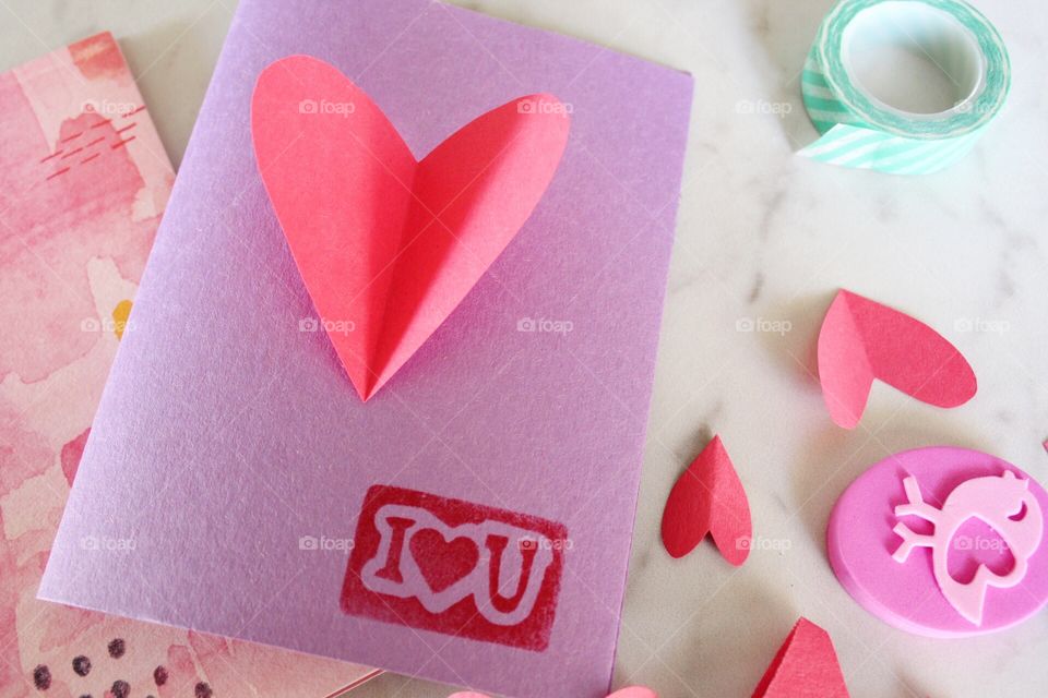 Homemade Valentine's Day greeting cards with stamps and heart cutouts.